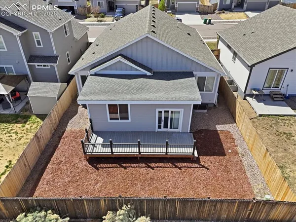 an aerial view of a house with wooden fence