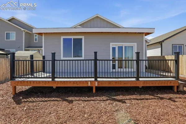 a view of a house with wooden fence