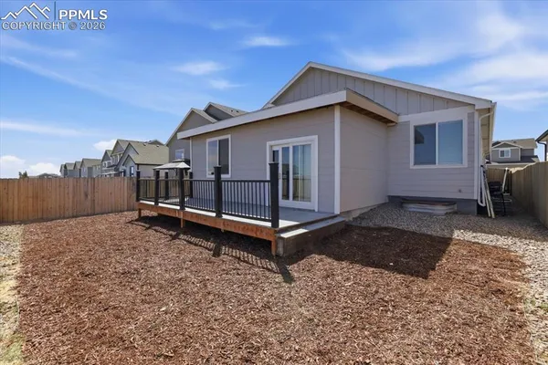 a view of a house with a yard and wooden fence
