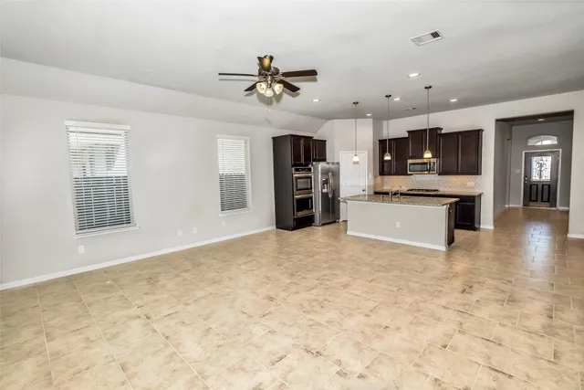 a kitchen with stainless steel appliances granite countertop a sink a stove a refrigerator and island