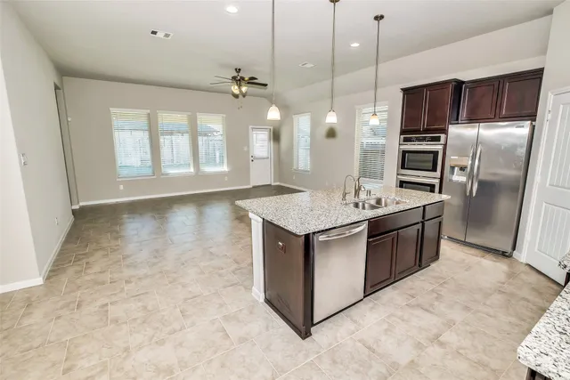 a large kitchen with a refrigerator and a stove top oven