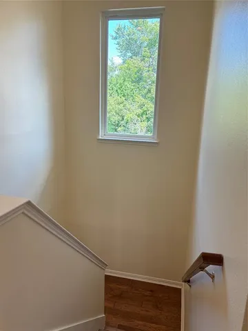 a view of n empty room with ceiling fan and window