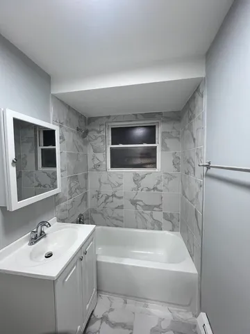 a bathroom with a sink a toilet a mirror and bathtub