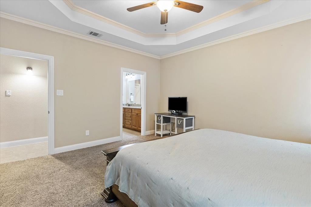 502 Ritchey Street Gainesville, TX 76240 - Photo 20 of 29 a bedroom with a bed and a flat screen tv