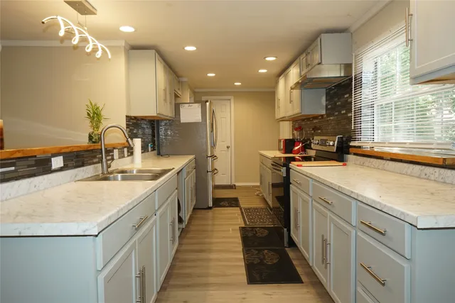 a kitchen with kitchen island a sink appliances and cabinets