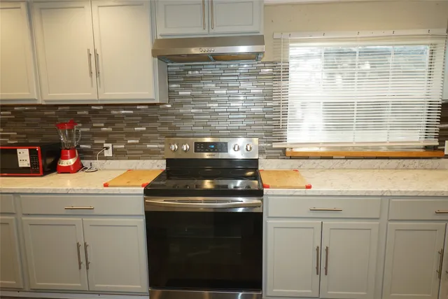 a kitchen with granite countertop white cabinets and white appliances