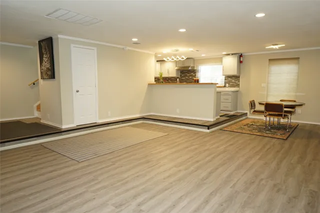 a view of a kitchen with kitchen island white cabinets and stainless steel appliances