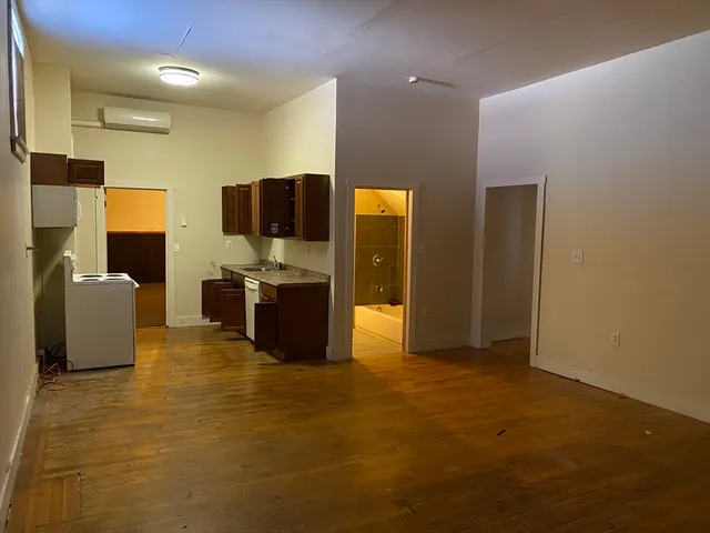 a kitchen with stainless steel appliances granite countertop a stove and a wooden floors