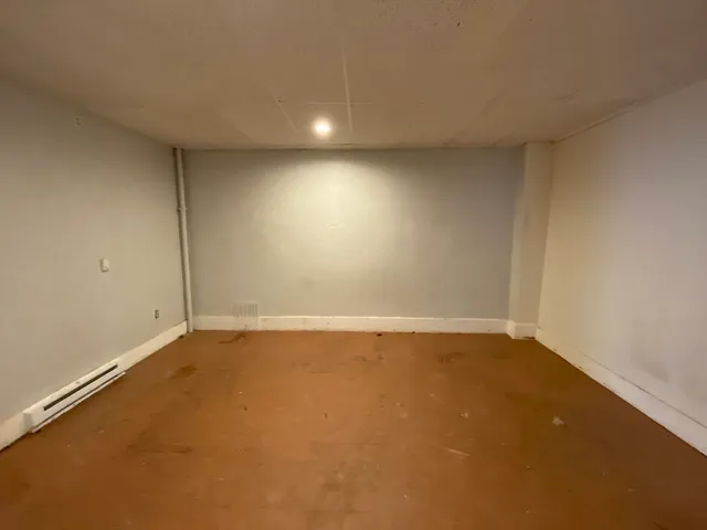 a view of a hallway with wooden floor and a living room