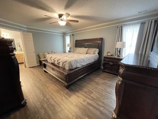 a spacious bedroom with a bed and wooden floor