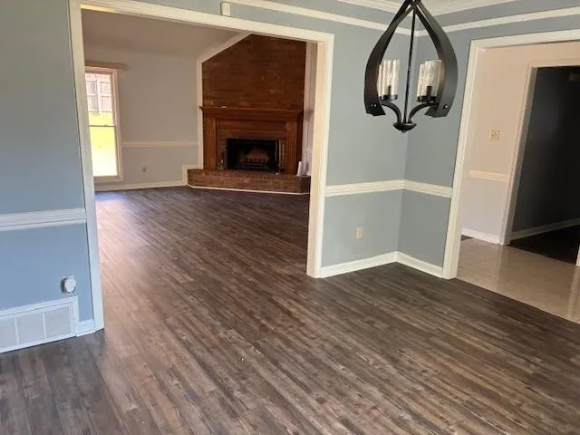 an empty room with wooden floor and a fireplace
