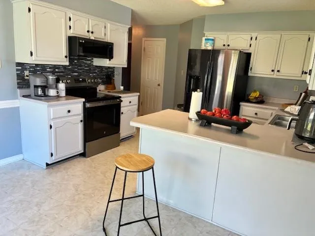 a kitchen with stainless steel appliances a stove refrigerator sink and cabinets