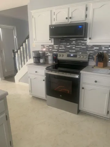 a kitchen with stainless steel appliances granite countertop a stove a sink and a microwave