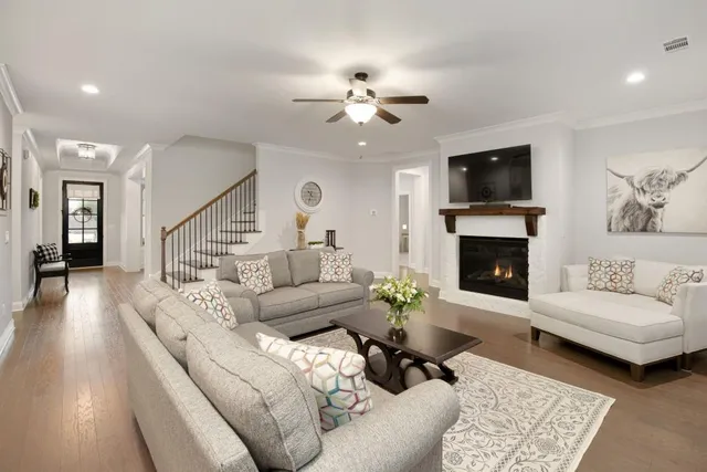 a kitchen with stainless steel appliances a sink a stove a refrigerator cabinets and a dining table with wooden floor