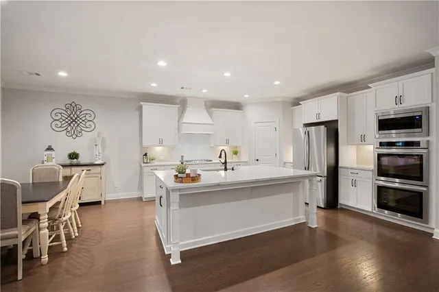 a kitchen that has a lot of cabinets a sink and appliances in it