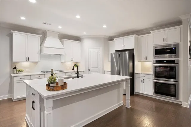 a kitchen with white cabinets and appliances