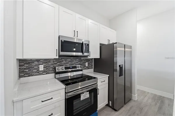 a kitchen with a stainless steel appliances white cabinets and a granite counter tops
