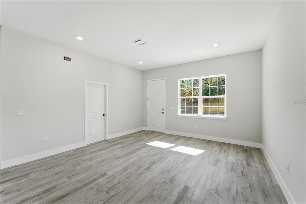 13205 Southwest 65th Circle Ocala, FL 34473 - Photo 12 of 32 an empty room with wooden floor and windows