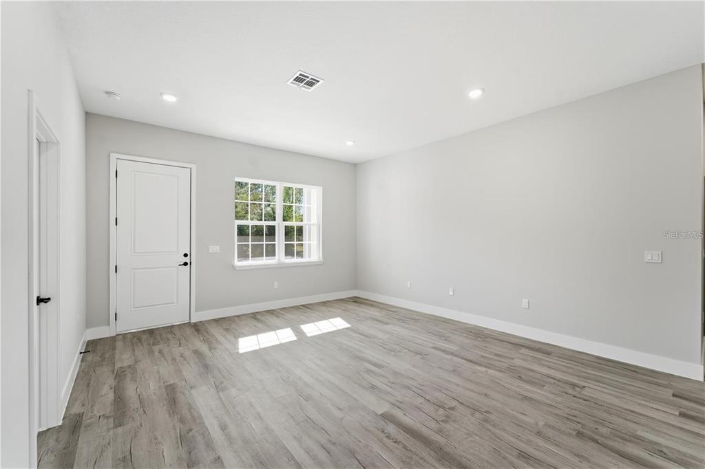 13205 Southwest 65th Circle Ocala, FL 34473 - Photo 13 of 32 a view of an empty room with wooden floor and a window