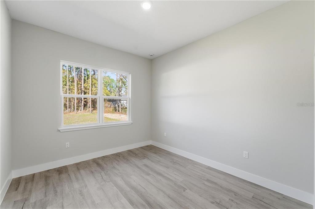 13205 Southwest 65th Circle Ocala, FL 34473 - Photo 14 of 32 an empty room with wooden floor and windows