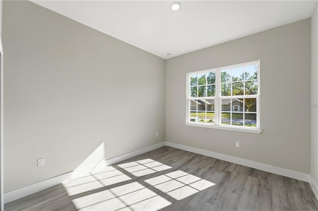 13205 Southwest 65th Circle Ocala, FL 34473 - Photo 16 of 32 an empty room with wooden floor and windows