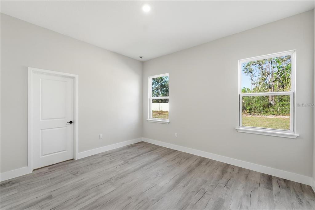 13205 Southwest 65th Circle Ocala, FL 34473 - Photo 17 of 32 a view of an empty room with wooden floor and a window