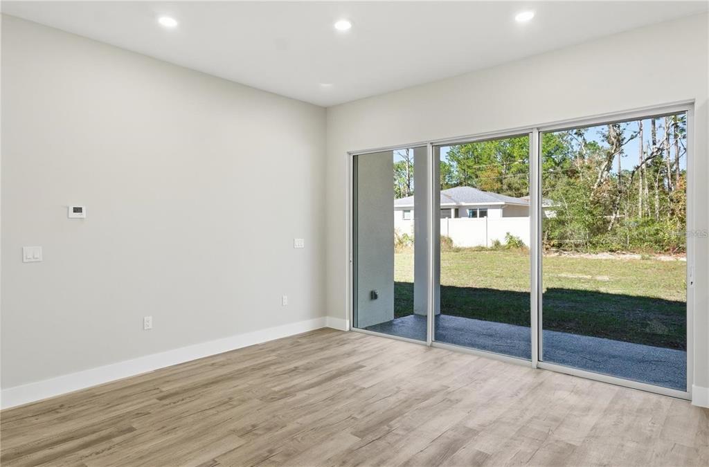 13205 Southwest 65th Circle Ocala, FL 34473 - Photo 2 of 32 a view of an empty room with wooden floor and a window