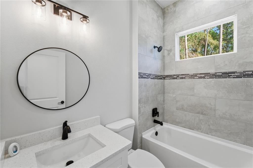 13205 Southwest 65th Circle Ocala, FL 34473 - Photo 23 of 32 a bathroom with a sink a toilet and a tub