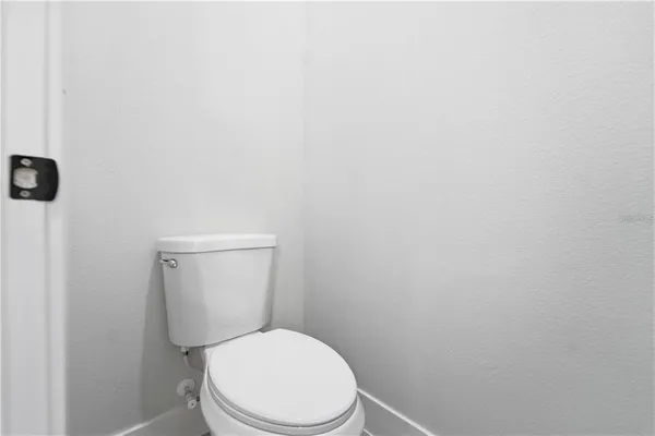 a white toilet sitting next to a white wall