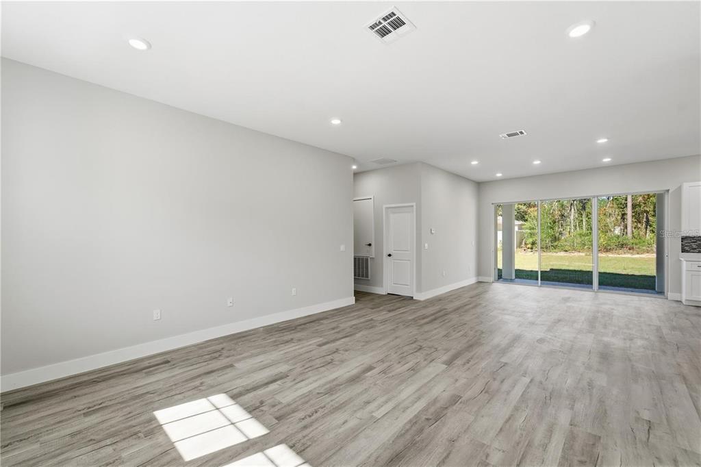 13205 Southwest 65th Circle Ocala, FL 34473 - Photo 4 of 32 an empty room with wooden floor and windows