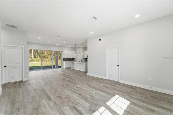 a view of empty room with wooden floor and window