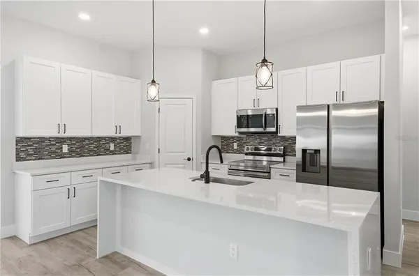 a kitchen with refrigerator a sink and microwave