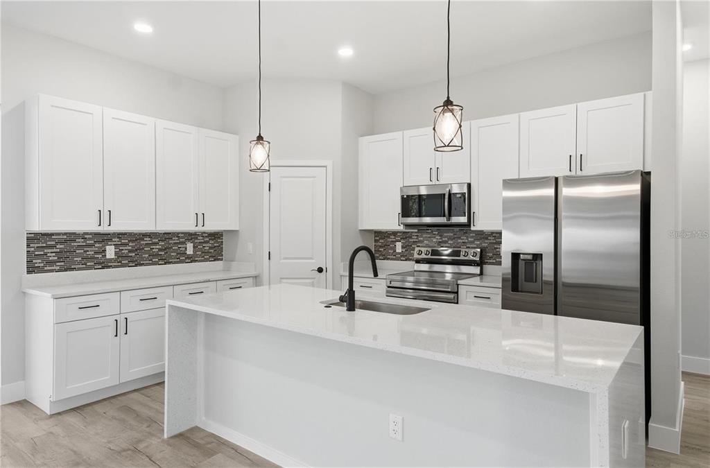 13205 Southwest 65th Circle Ocala, FL 34473 - Photo 7 of 32 a kitchen with refrigerator a sink and microwave