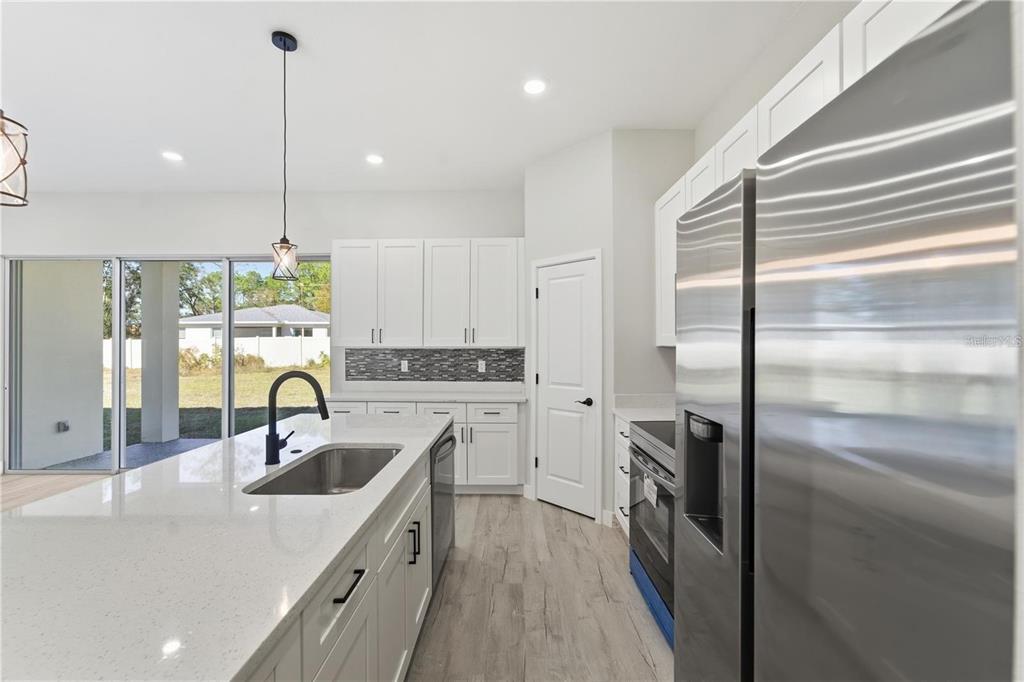 13205 Southwest 65th Circle Ocala, FL 34473 - Photo 10 of 32 a kitchen with kitchen island a sink a counter top space stainless steel appliances and cabinets
