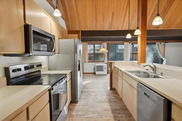 a kitchen with stainless steel appliances a stove microwave and sink
