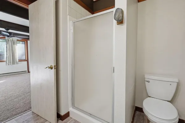 a white toilet sitting next to a shower