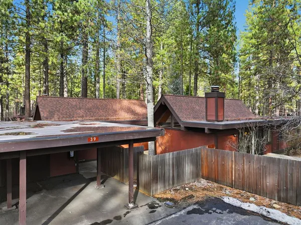 a view of a wooden deck and trees with wooden fence