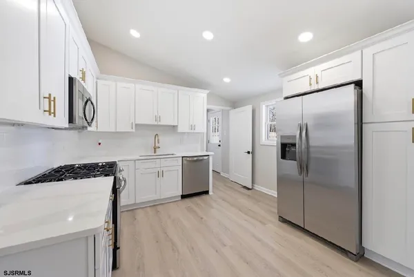a kitchen with a refrigerator a sink and cabinets