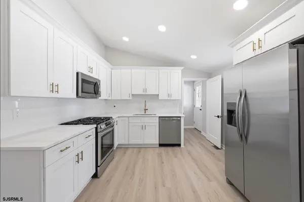 a kitchen with stainless steel appliances granite countertop a stove a sink and a refrigerator