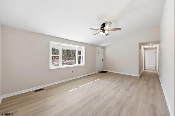 a view of an empty room with a window and a ceiling fan