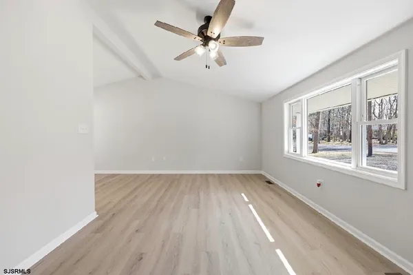 wooden floor in an empty room with a window