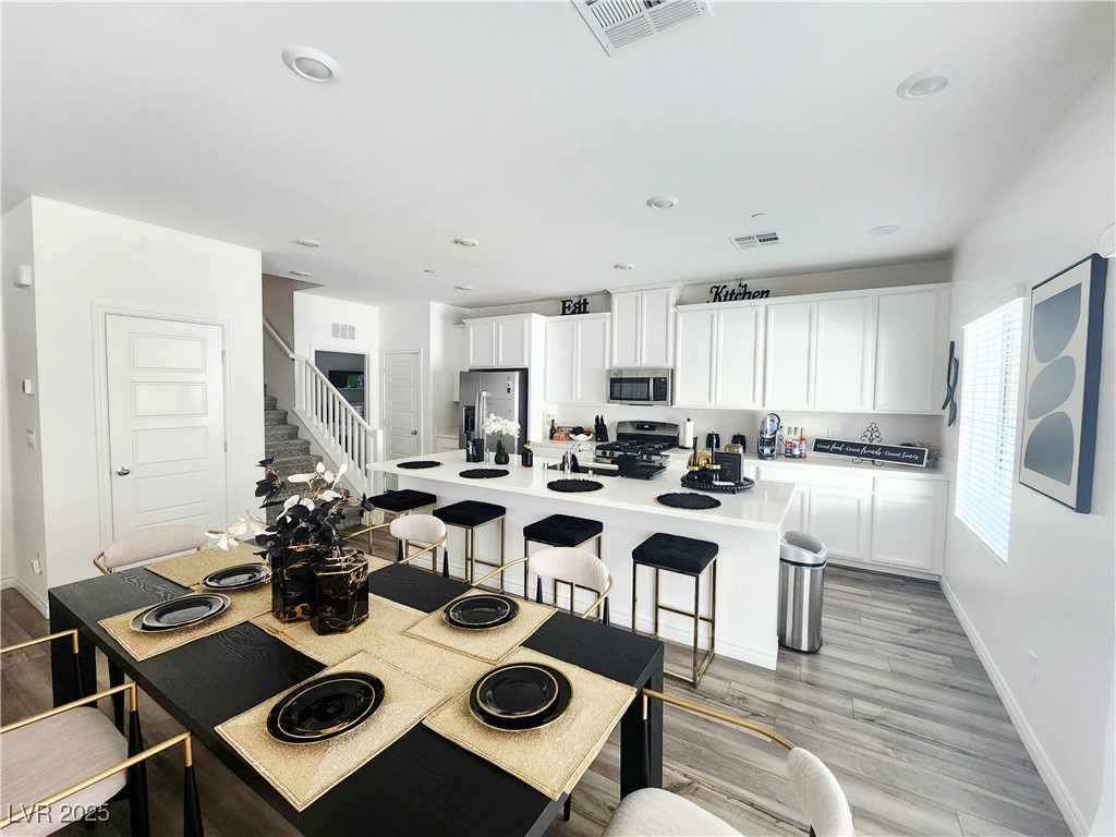 Dining space with light wood-style flooring and recessed lighting