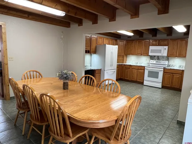 a kitchen with stainless steel appliances kitchen island granite countertop a dining table and chairs