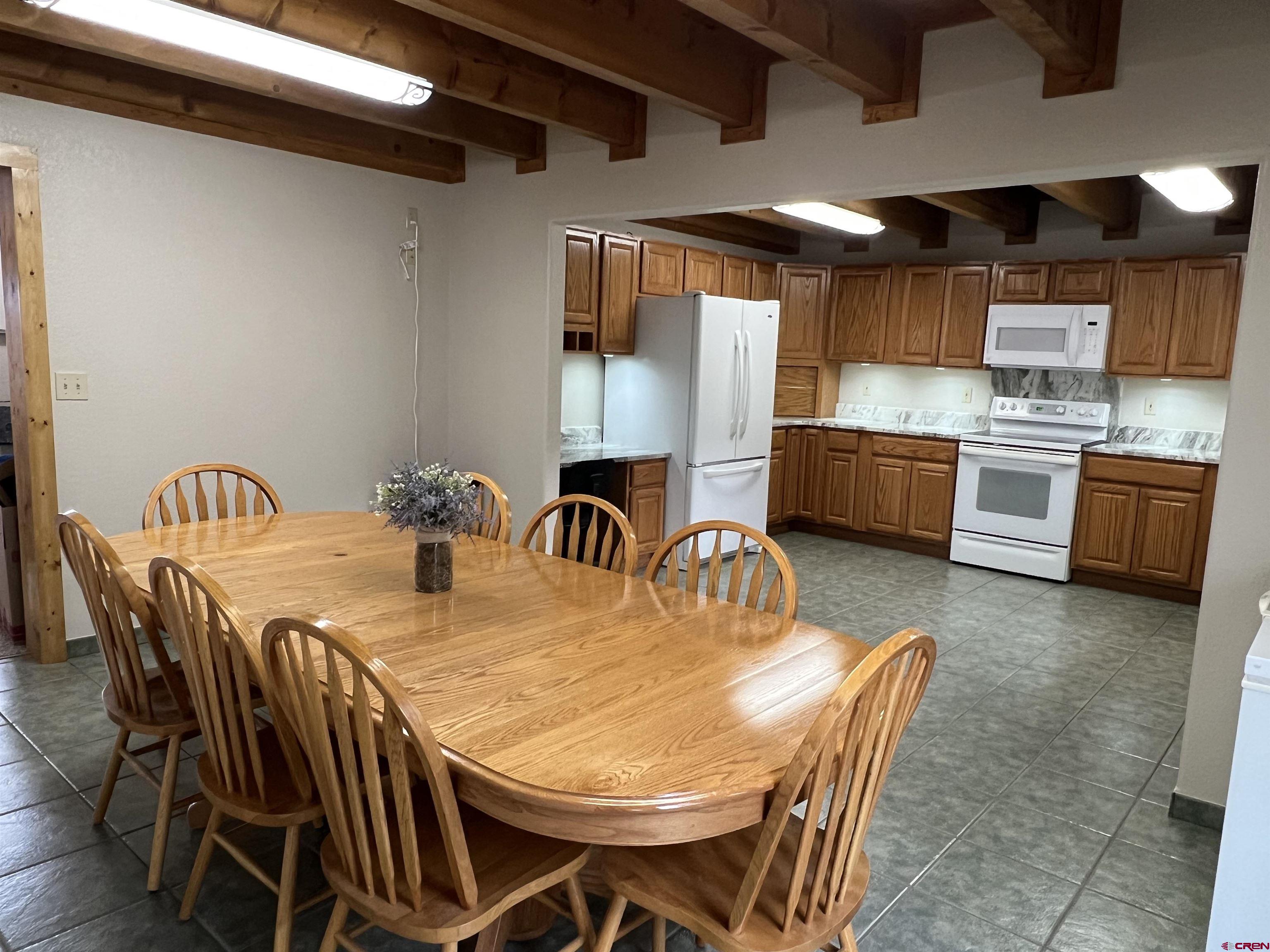 41400 Co Road Saguache, CO 81149 - Photo 14 of 45 a kitchen with stainless steel appliances kitchen island granite countertop a dining table and chairs