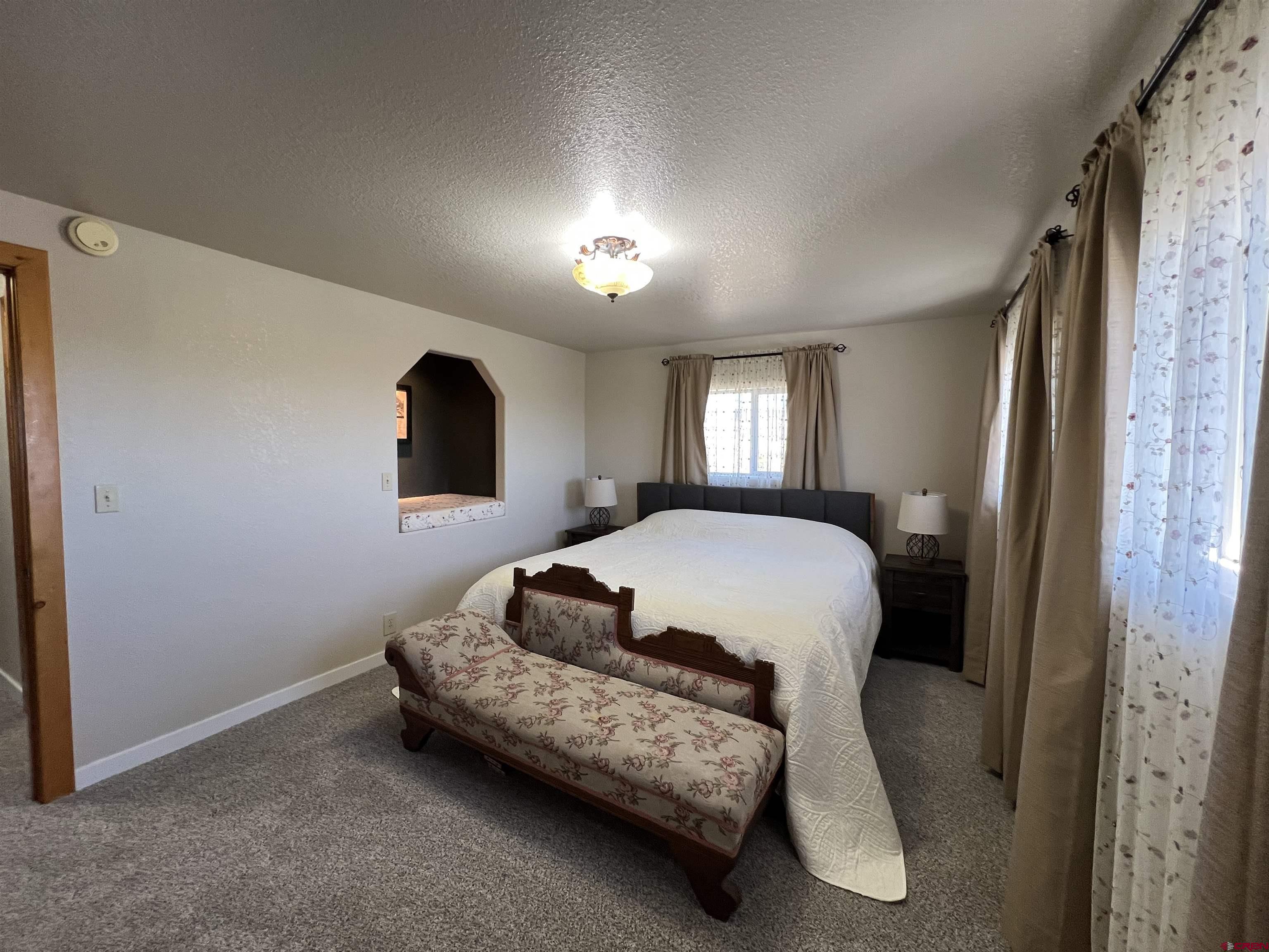 41400 Co Road Saguache, CO 81149 - Photo 20 of 45 a bedroom with a bed lamp and a window
