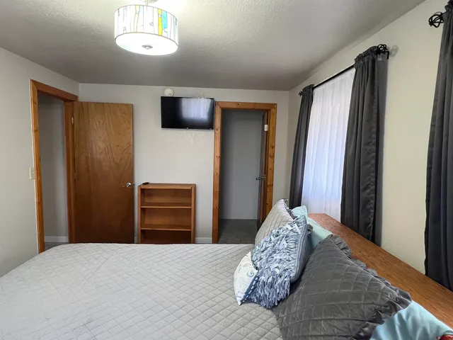 a bedroom with a chair and a window