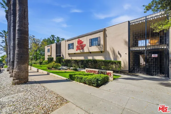 a front view of a building with a garden