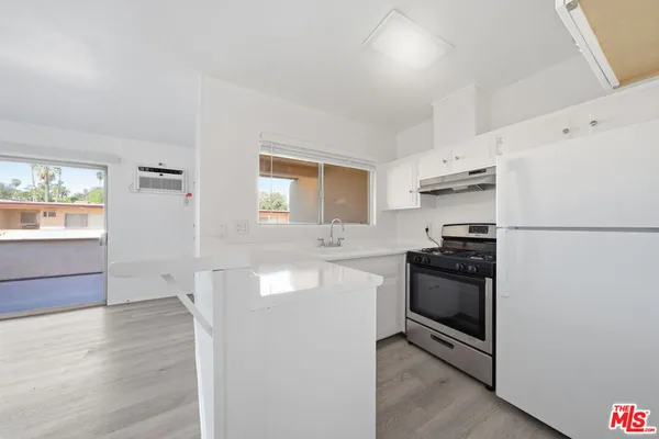 a kitchen with granite countertop a refrigerator stove and sink
