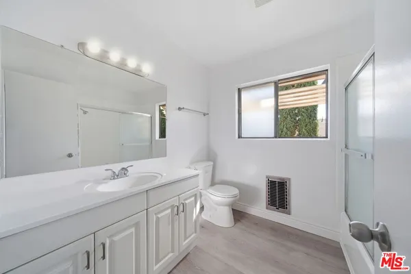 a bathroom with a double vanity sink a toilet and a mirror
