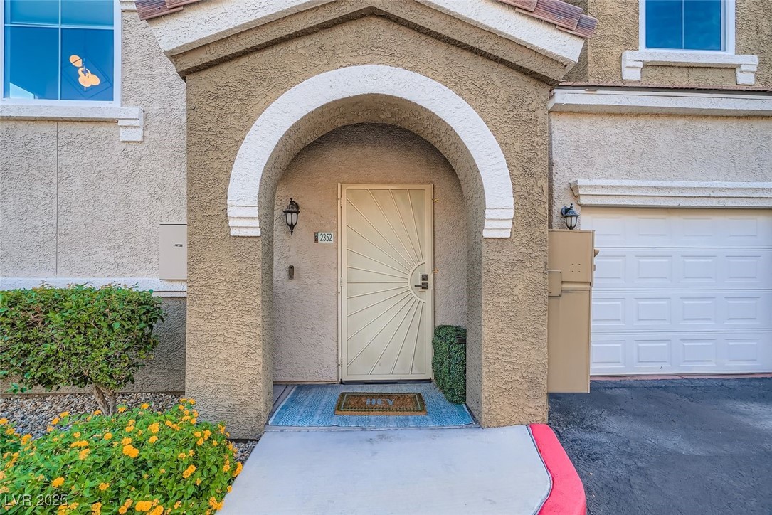 10001 Peace Way, Unit 2352 Las Vegas, NV 89147 - Photo 3 of 24 View of exterior entry featuring stucco siding and a garage